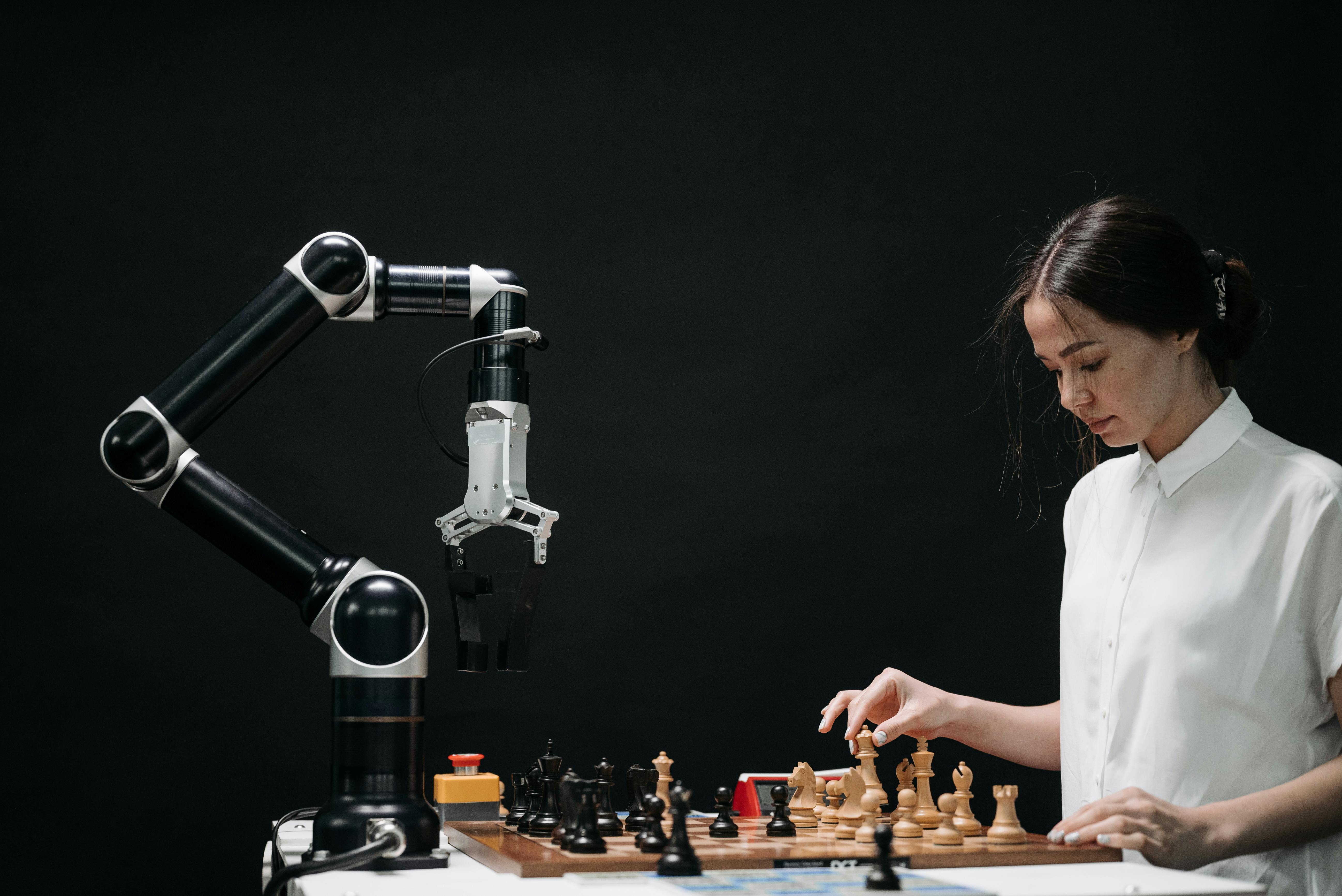 Person playing chess with a robot arm